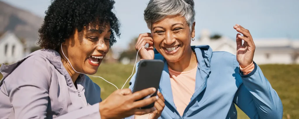 Two women watching a video on a smart phone.