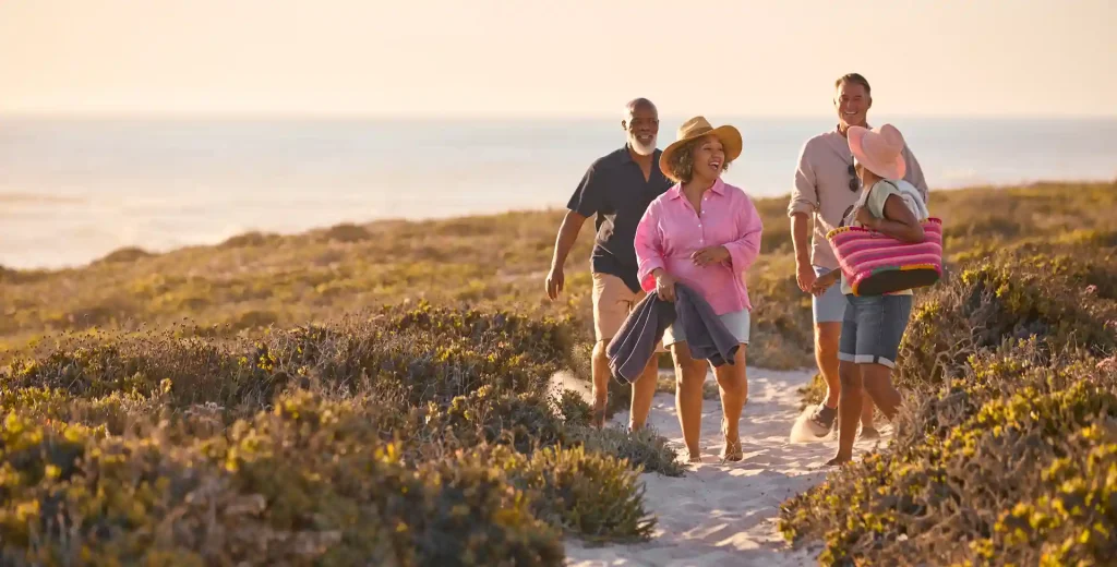 Four people walking and talking on the beach